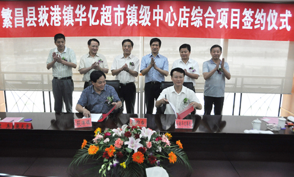 5.华亿超市总经理吴文骏与荻港镇镇长罗彦顺代表双方顺利签约.jpg