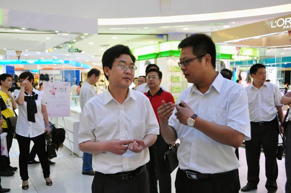 9.华亿国际常务副总经理张树华正在向鲍传华同志介绍商场.jpg